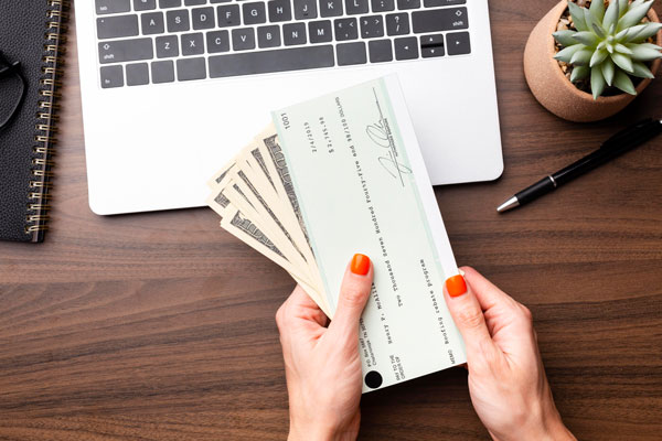 close up hands holding cash check